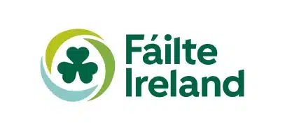 Fáilte Ireland logo featuring a green shamrock surrounded by two circular brushstrokes, one green and one light blue, with the words "Fáilte Ireland" in bold green text on the right—perfect for events like the Kilkenny Animated Festival.