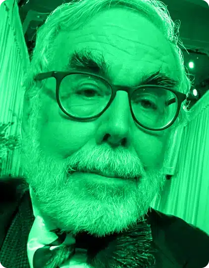 A close-up selfie of an older man with glasses, white hair, and a beard, wearing a suit and tie. The image has a strong green colour filter, capturing the creative spirit often seen at the Kilkenny Animated Festival.