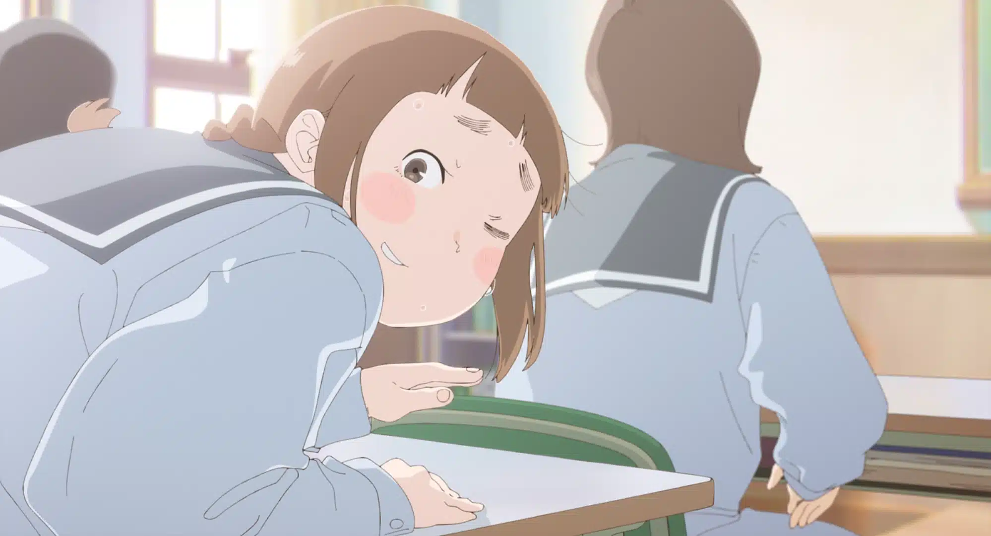 A girl in a school uniform leans forward at her desk, winking awkwardly with a flushed face and sweat drops, whilst another pupil sits nearby, facing away.