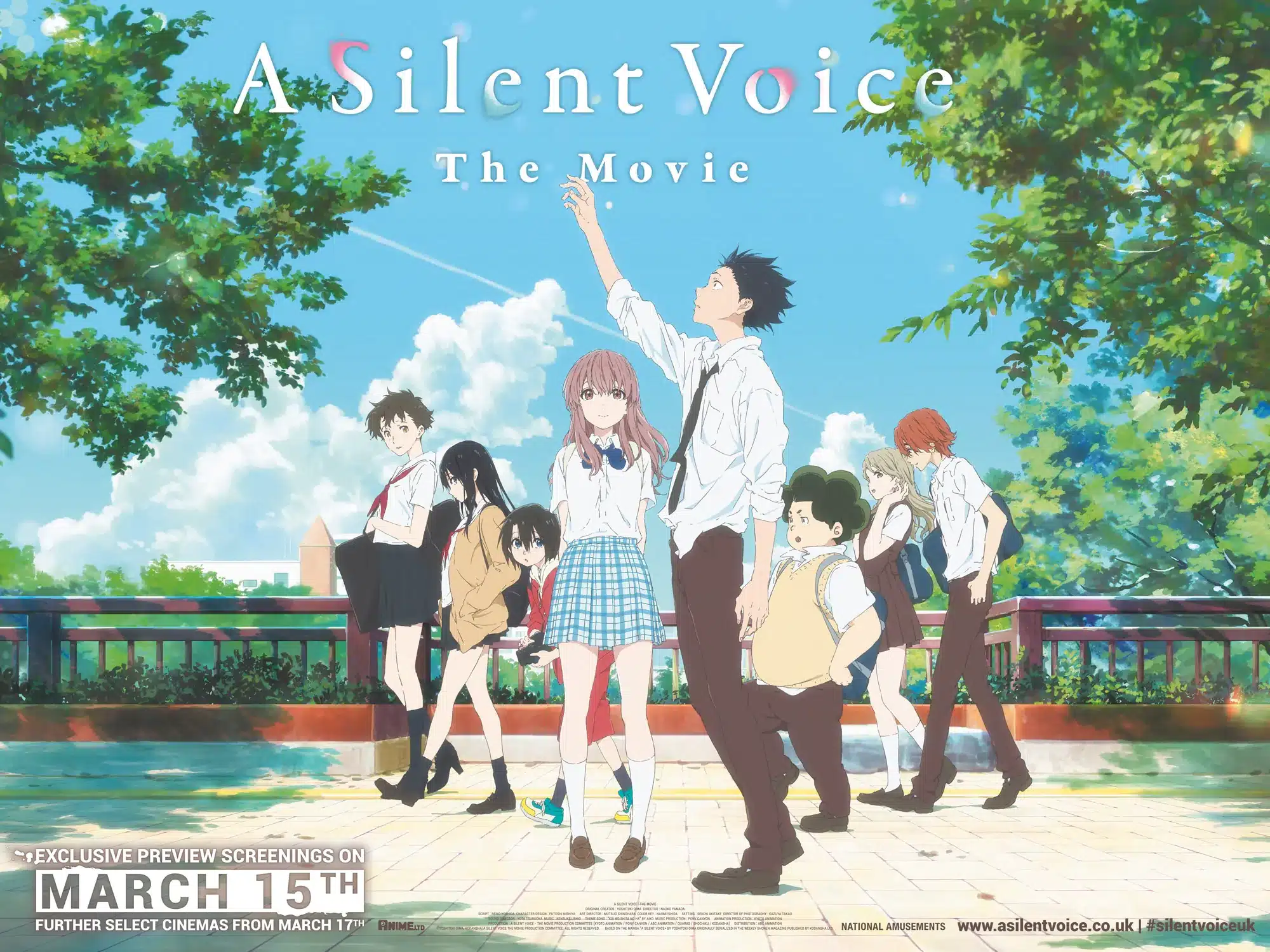 A group of anime students in school uniforms stand together in a sunny park. The main girl raises her hand whilst others pose around her. Text reads, "A Silent Voice The Movie" with a release date of 15 March.